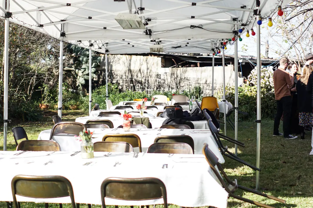 Round event tables and chairs arranged beneath a tent